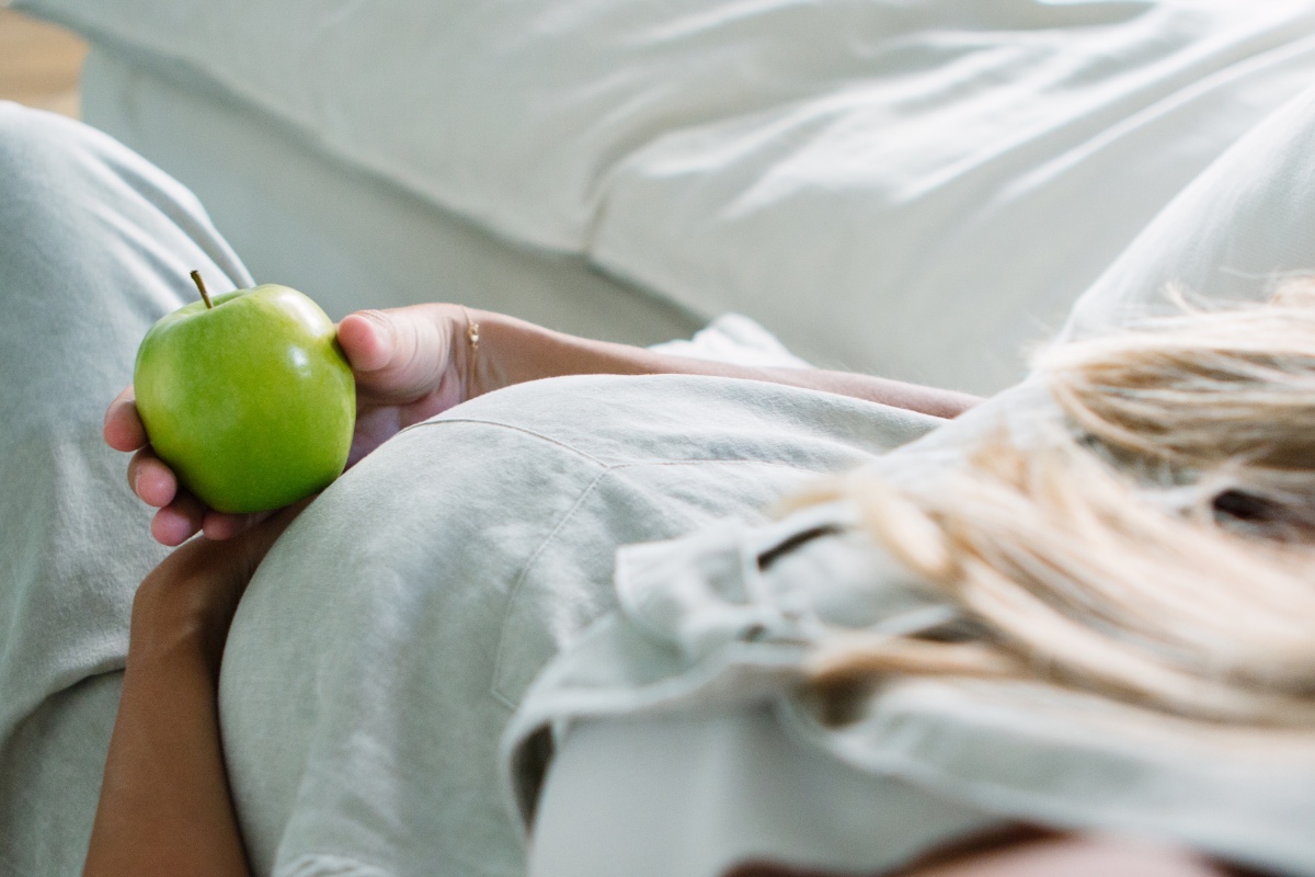 Photo of pregnant woman's belly holding an apple